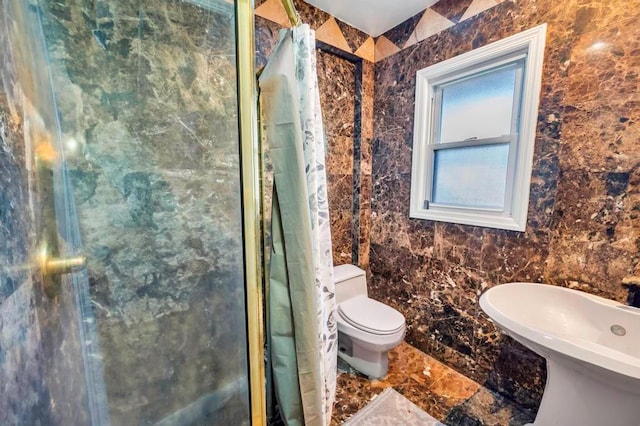 bathroom featuring toilet and a shower with shower door