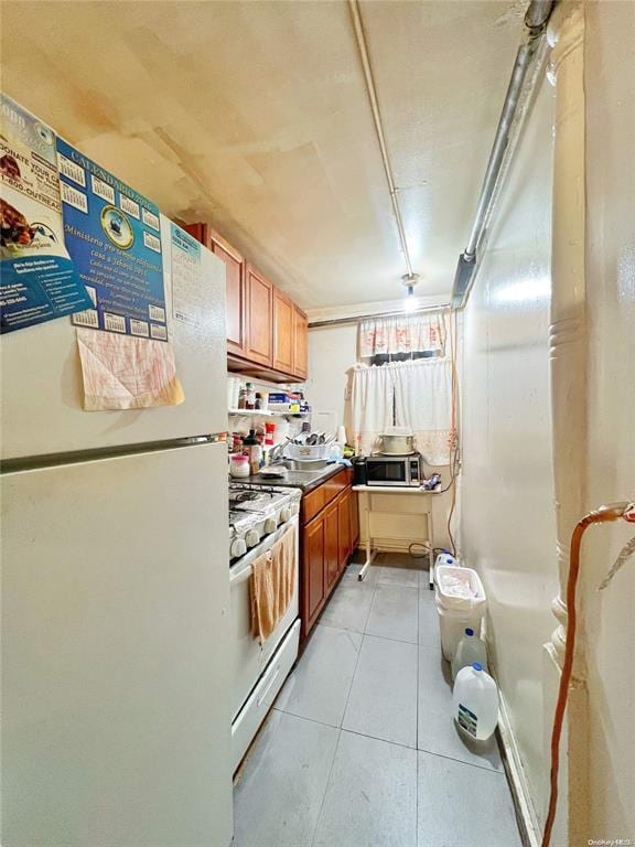 kitchen featuring light tile patterned flooring and white appliances