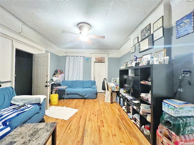 interior space with wood-type flooring, a textured ceiling, and ceiling fan