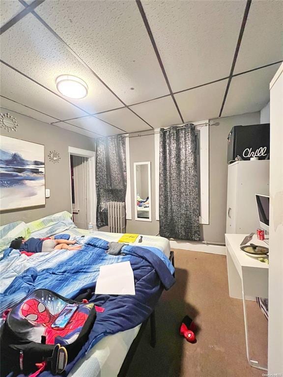 bedroom with carpet flooring and a paneled ceiling