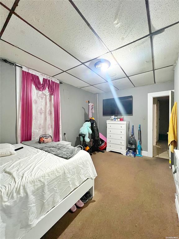 bedroom featuring a paneled ceiling and carpet flooring