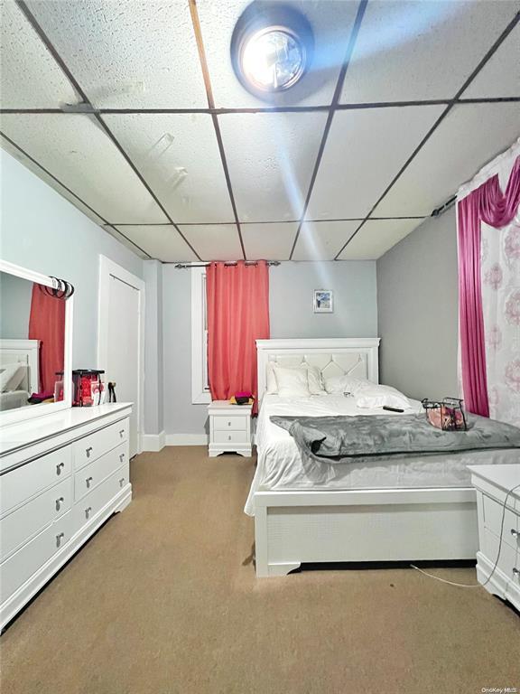 carpeted bedroom featuring a paneled ceiling