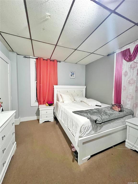 carpeted bedroom with a paneled ceiling