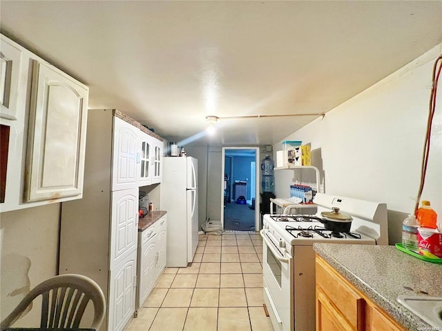 kitchen featuring light tile patterned floors and white appliances