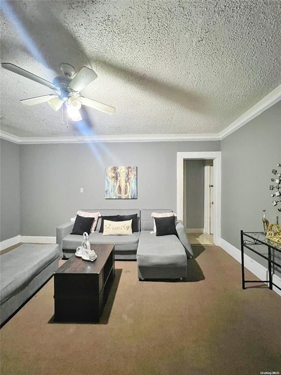 living room with crown molding and a textured ceiling