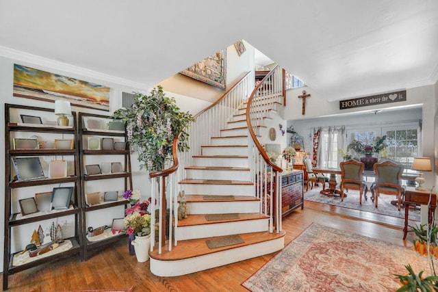 staircase featuring ornamental molding and hardwood / wood-style flooring