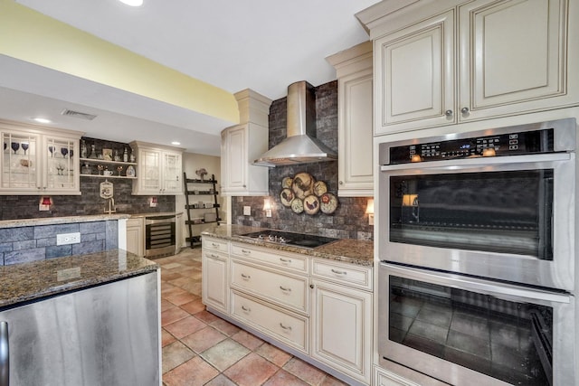 kitchen with backsplash, wine cooler, wall chimney exhaust hood, cooktop, and stainless steel double oven