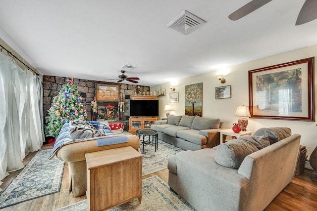 living room featuring wood-type flooring and ceiling fan