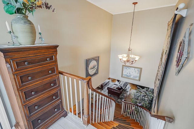 stairs with wood-type flooring and an inviting chandelier