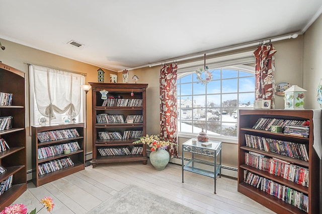 sitting room with light hardwood / wood-style floors, ornamental molding, and a baseboard heating unit