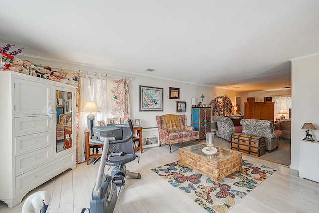 living room with crown molding and light hardwood / wood-style floors