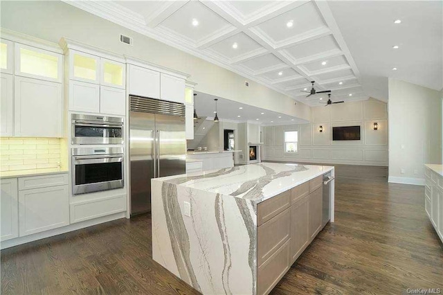 kitchen featuring dark wood finished floors, coffered ceiling, open floor plan, and appliances with stainless steel finishes