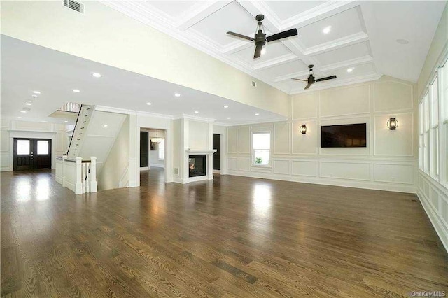 unfurnished living room featuring a decorative wall, visible vents, coffered ceiling, and a ceiling fan