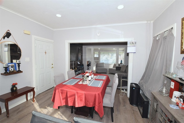 dining area with hardwood / wood-style floors and ornamental molding