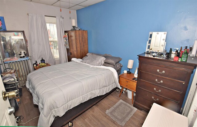 bedroom featuring hardwood / wood-style flooring and a drop ceiling