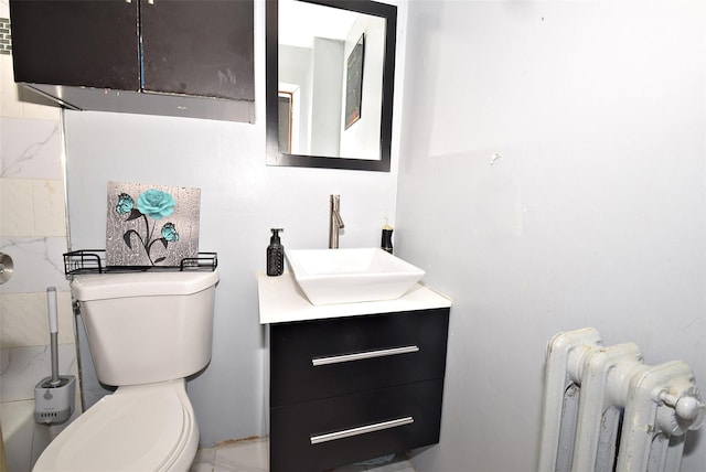 bathroom with radiator heating unit, vanity, and toilet