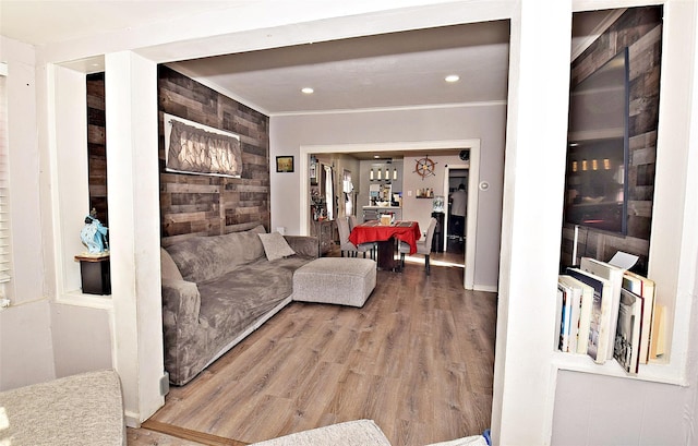 living room featuring wood-type flooring, crown molding, and wooden walls