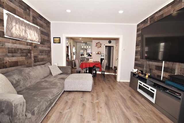 living room featuring wood walls, crown molding, and wood-type flooring