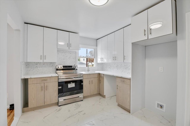 kitchen with backsplash, white cabinets, sink, and stainless steel range with electric cooktop