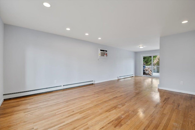 spare room featuring light hardwood / wood-style floors, a wall mounted AC, and a baseboard radiator