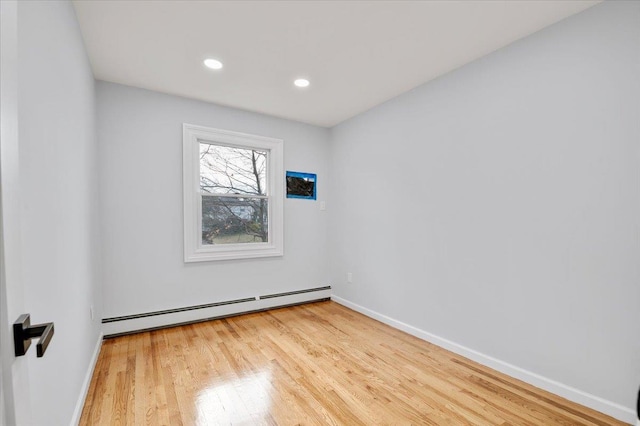 empty room with baseboard heating and wood-type flooring