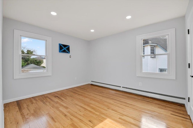 unfurnished room featuring light wood-type flooring and baseboard heating