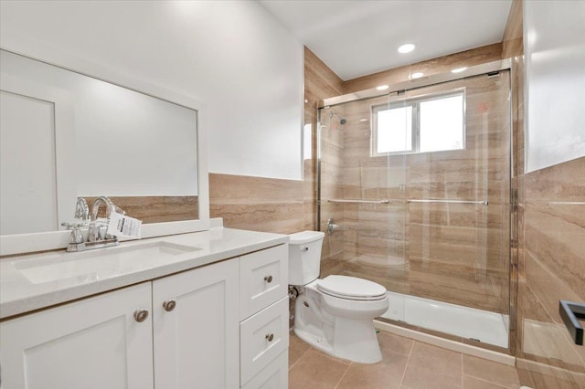 bathroom with walk in shower, tile patterned flooring, toilet, vanity, and tile walls