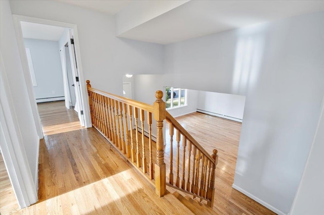 stairs featuring hardwood / wood-style floors and a baseboard radiator