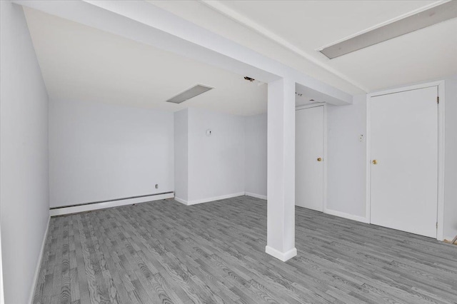 basement featuring hardwood / wood-style floors and baseboard heating