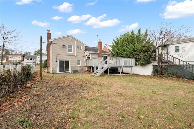 rear view of house featuring a lawn and a wooden deck