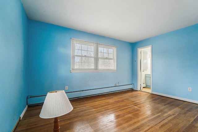 unfurnished room with dark wood-type flooring and a baseboard heating unit