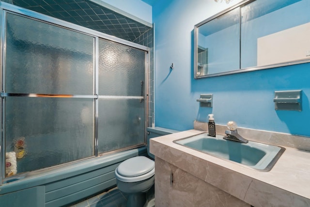 full bathroom featuring shower / bath combination with glass door, toilet, and vanity