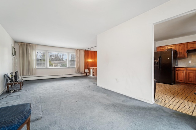 unfurnished living room featuring baseboard heating and carpet