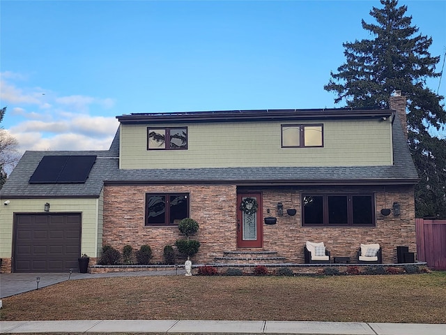 view of front of home featuring a garage and solar panels