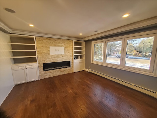 unfurnished living room featuring dark wood-type flooring, a baseboard heating unit, a fireplace, built in features, and crown molding