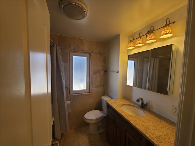 bathroom featuring toilet, tile patterned floors, vanity, and curtained shower