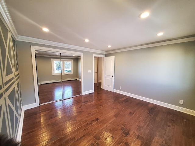 unfurnished bedroom with a closet, dark wood-type flooring, and crown molding