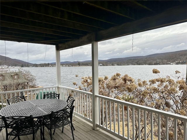 wooden terrace featuring a water and mountain view