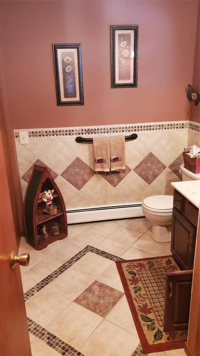 bathroom with vanity, tile patterned floors, baseboard heating, and tile walls