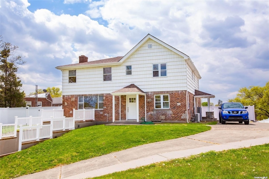 view of front of property with cooling unit and a front yard