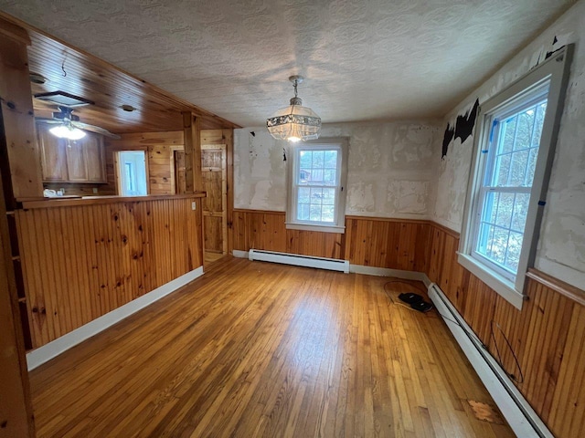 unfurnished dining area with a wealth of natural light and a baseboard heating unit