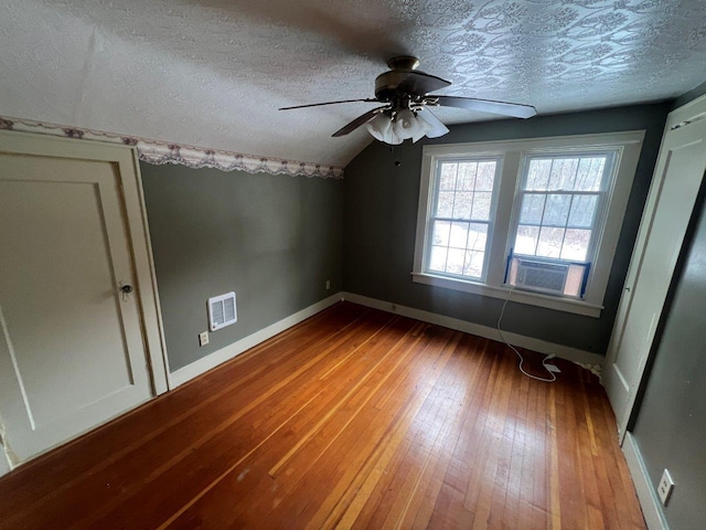 additional living space with ceiling fan, cooling unit, a textured ceiling, lofted ceiling, and hardwood / wood-style flooring