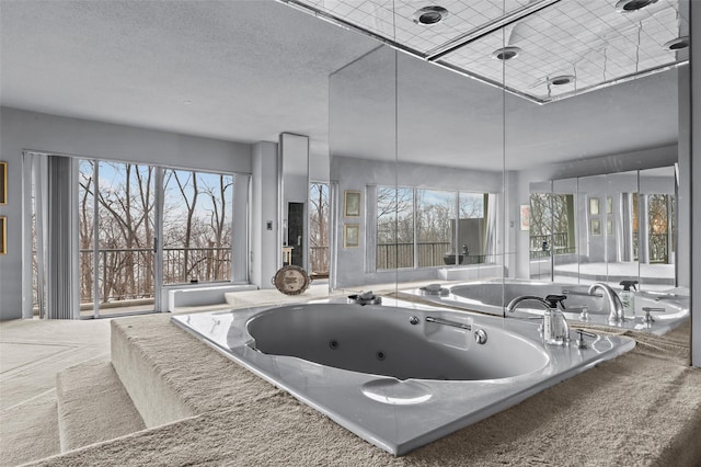 bathroom featuring a relaxing tiled tub and a textured ceiling