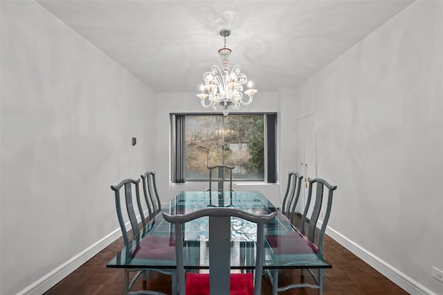 dining area featuring dark parquet floors and a chandelier