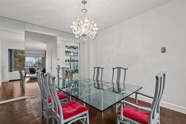 dining room featuring a notable chandelier and dark parquet floors