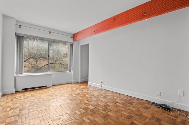 spare room with light parquet flooring and radiator