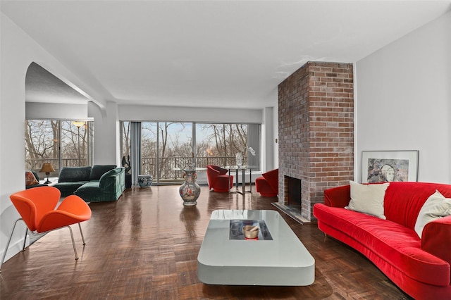 living room featuring a fireplace and dark parquet floors