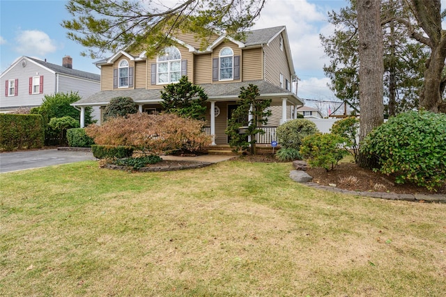 view of property with a front yard and a porch