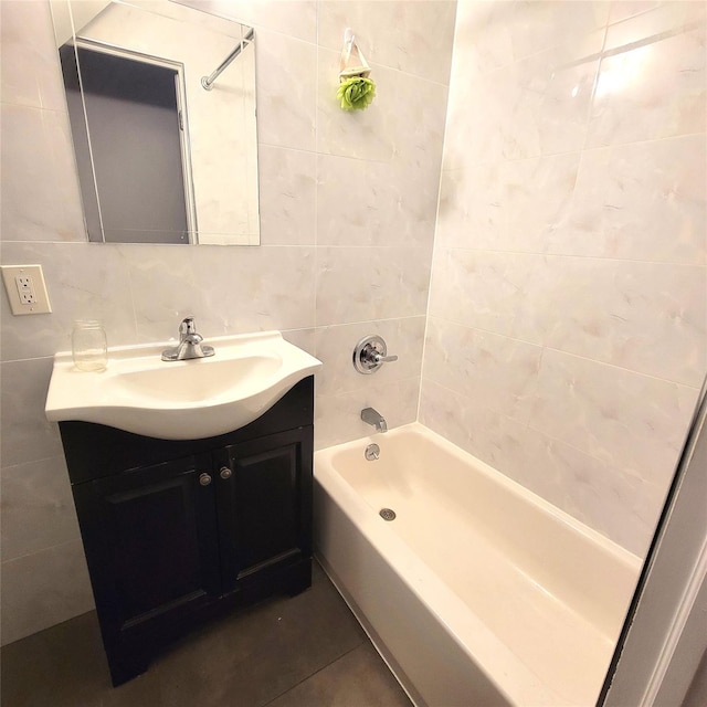 bathroom with vanity, bathing tub / shower combination, tile patterned floors, and tile walls