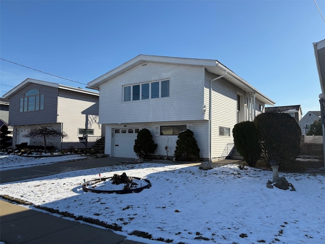 snow covered property with a garage